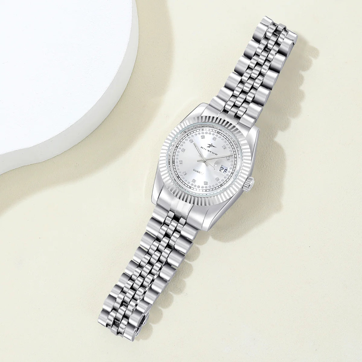 A women's quartz wristwatch with a textured bezel design and diamond studded dial decoration, equipped with date display functio