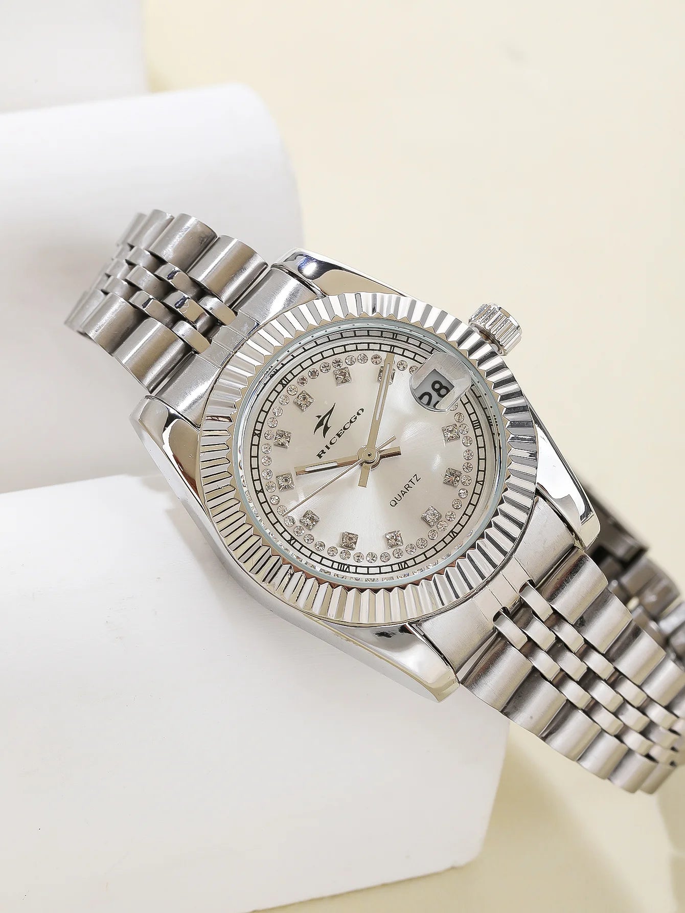 A women's quartz wristwatch with a textured bezel design and diamond studded dial decoration, equipped with date display functio