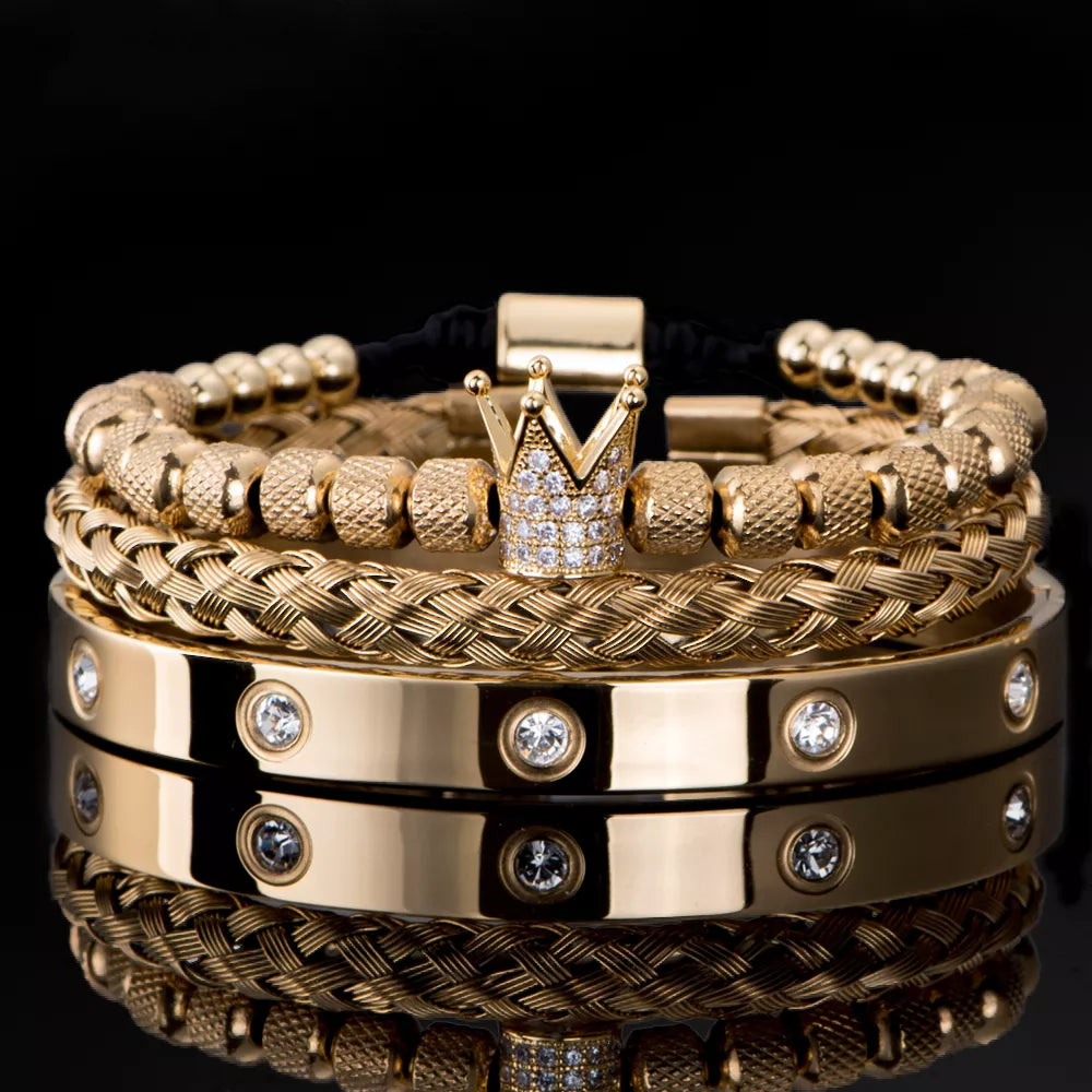 Gold bracelets with crown design and diamond accents on a black background